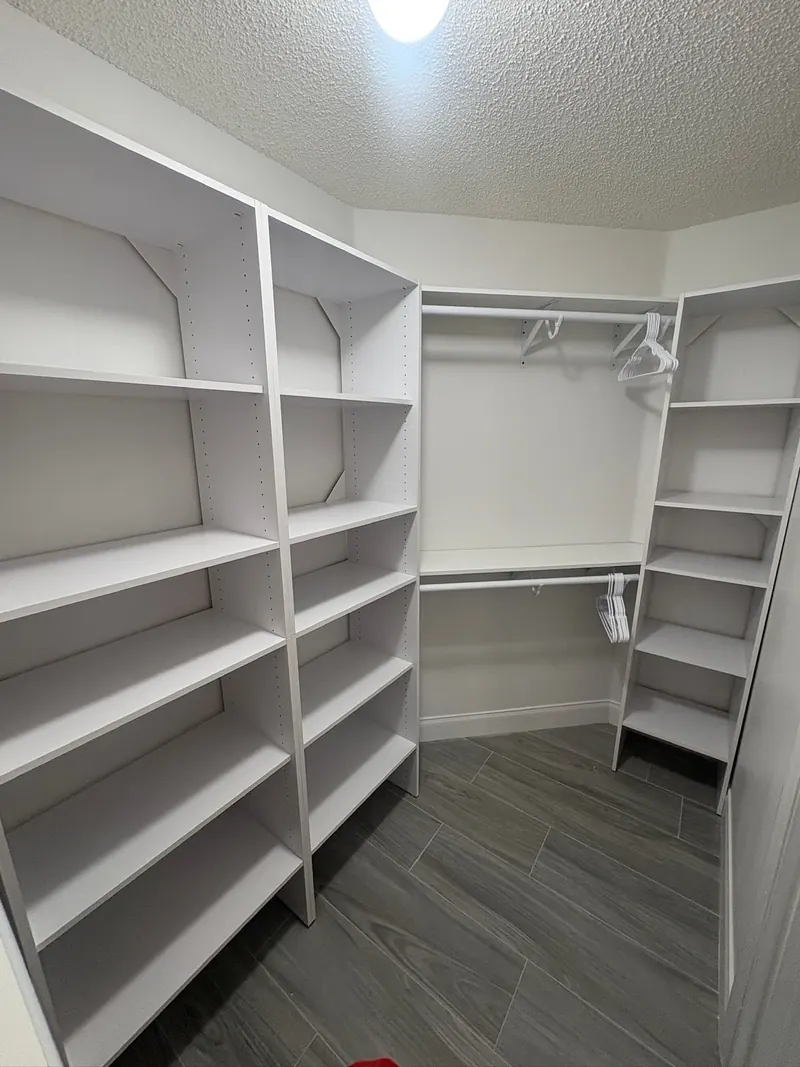Walk-in closet with floor-to-ceiling white shelving towers