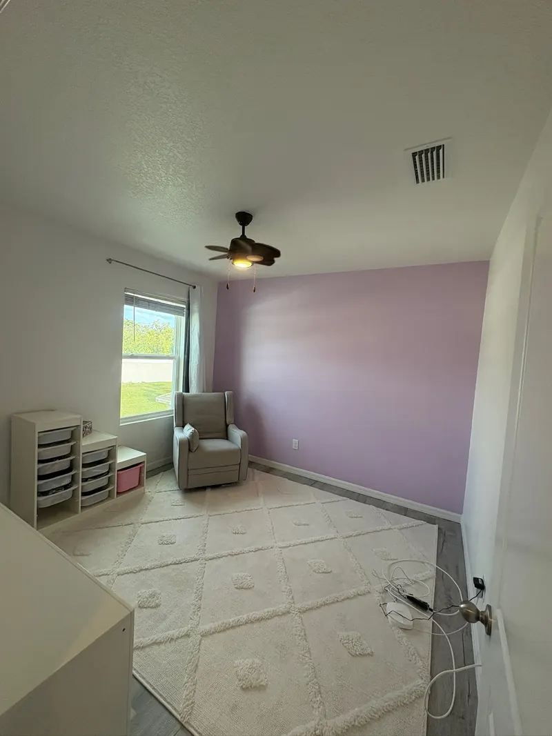 Bedroom with a freshly painted lavender accent wall