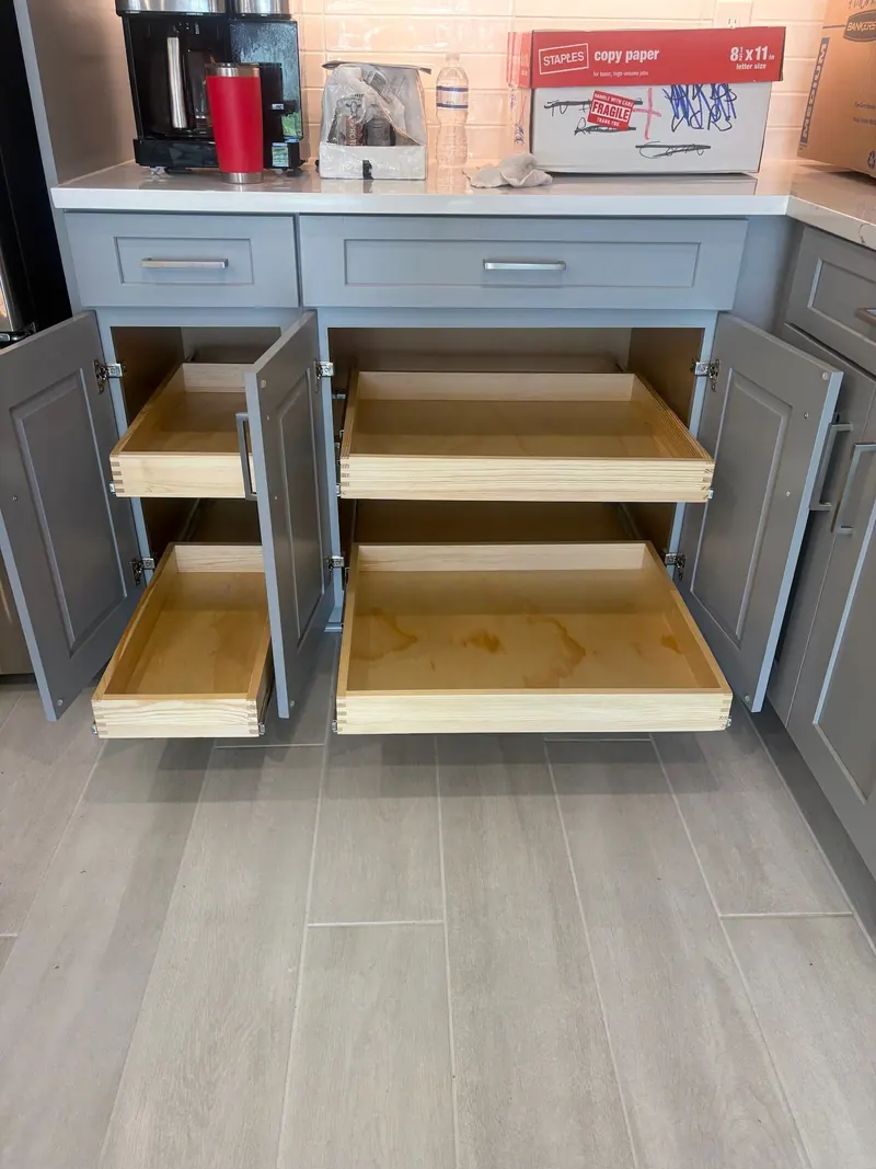 Lower kitchen cabinets fitted with wooden pull-out pantry drawers
